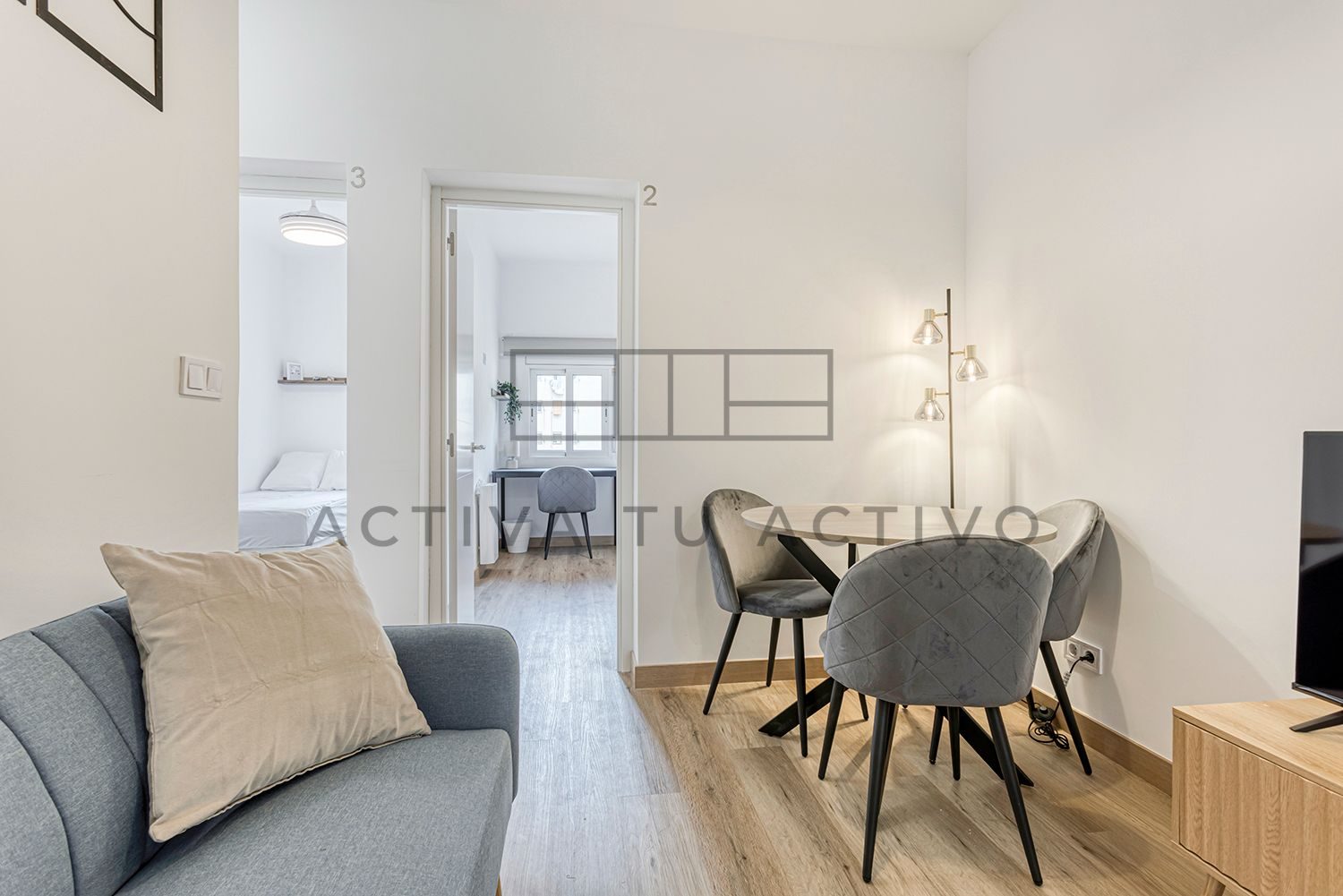 Salón de un piso reformado por ATA con mesa redonda y habitaciones